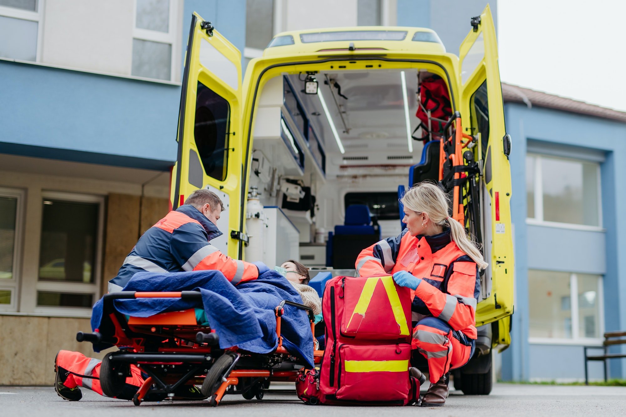 Rescuers taking care of patient, preparing her for transport.